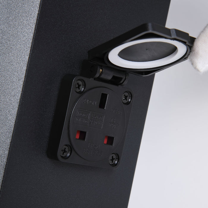 Close-up of the black garden power post's UK socket with its hinged waterproof flap lifted open