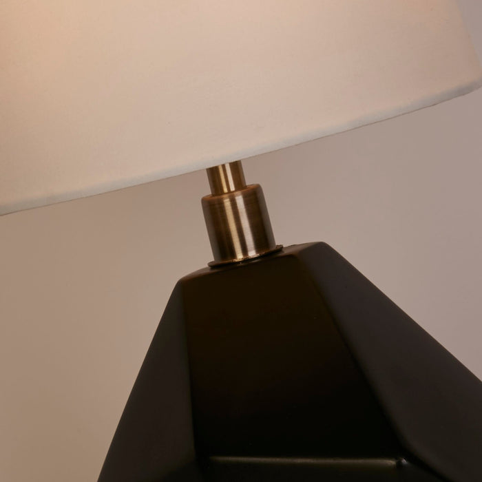 Detail of the Apex lamp's faceted black ceramic base and antique brass collar