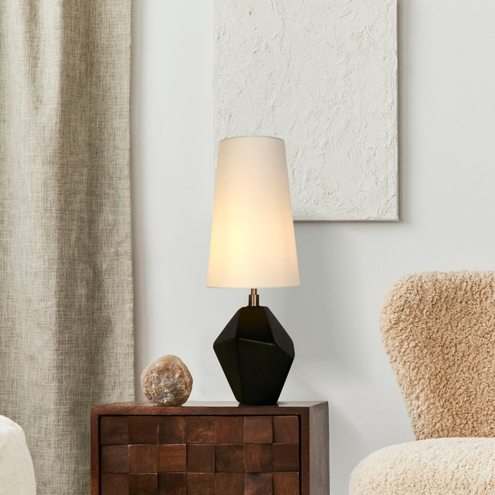 Apex lamp glowing on a chunky wooden sideboard beside a boucle chair and textured wall art