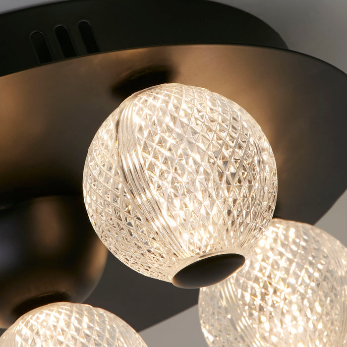 Close-up of the Asteroid light's textured clear glass globes on a black backplate