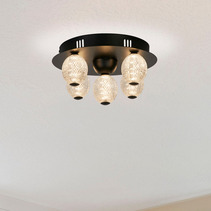 Ceiling view of the Asteroid black globe light glowing softly in a pale plain room
