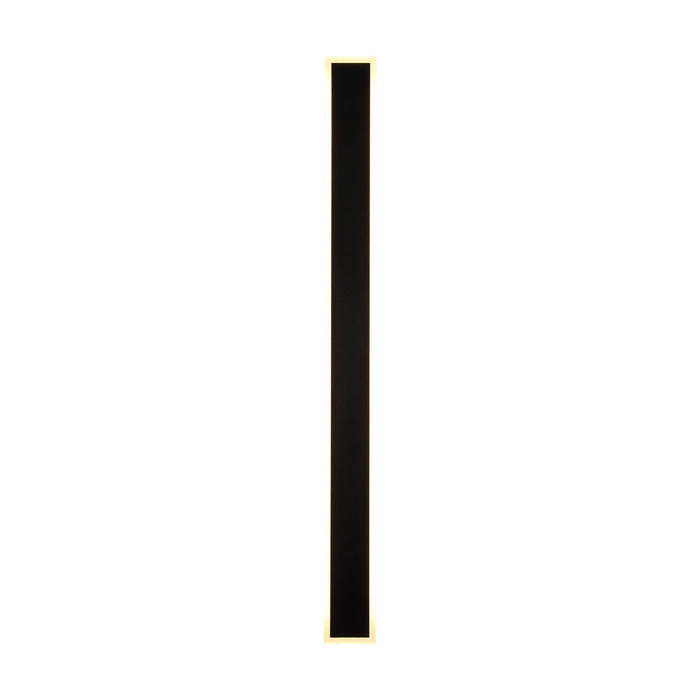 Bordo sand black square LED wall light lit as a tall slim bar with a glowing warm outline