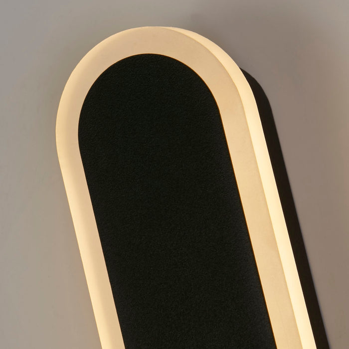 Detail of the Bordo bar's rounded top corner and illuminated warm acrylic edge on a grey wall