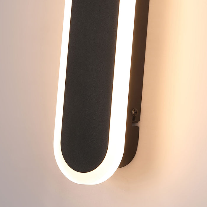 Close-up of the Bordo wall light's textured black face and softly glowing LED diffuser edge