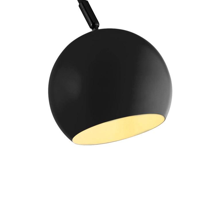 Close-up of the Calumn matt black ball shade and slim arm, warm cream interior visible beneath