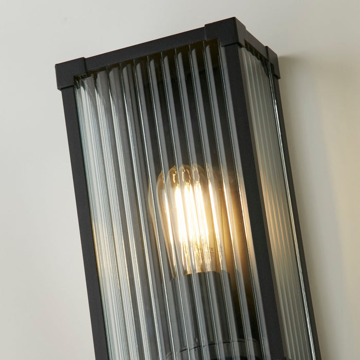 Close-up of the Cincinnati lantern's ribbed glass and glowing filament bulb in its black frame