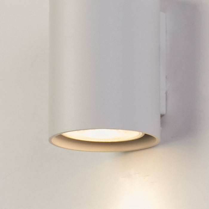 Close-up of Cyls white cylinder's open base and warm downward beam on the wall