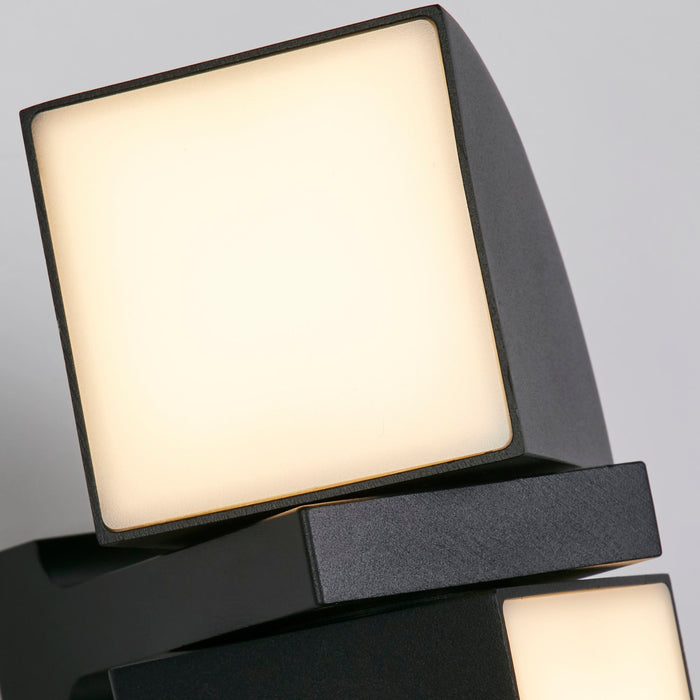 Close-up of the Dakota black wall light's square opal LED panel glowing warm on its curved plate