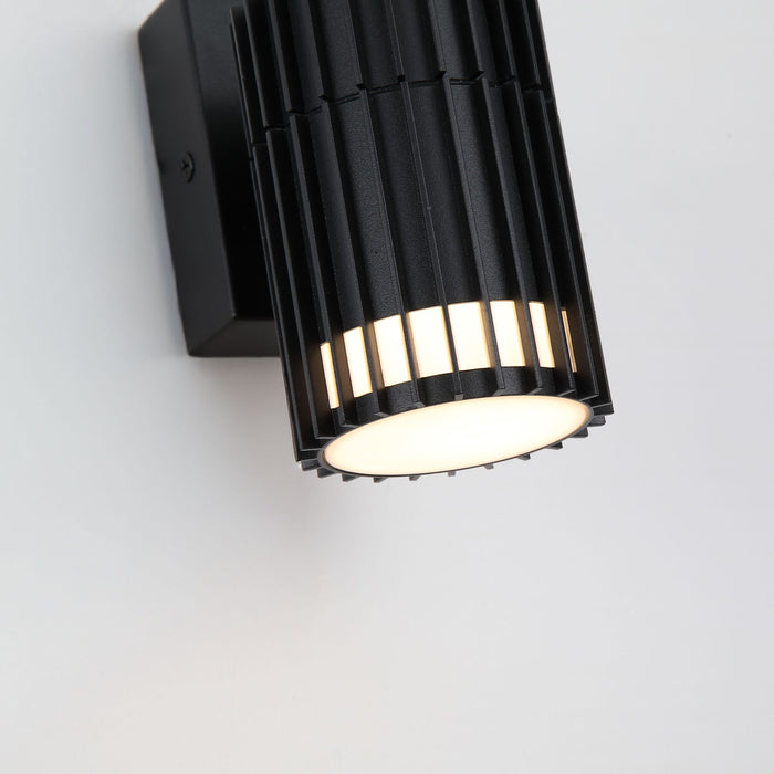 Detail of the Detroit black slatted cylinder with warm light glowing between its vertical fins