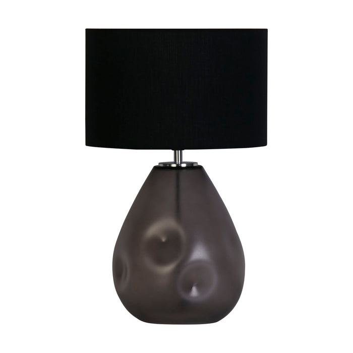Devon black table lamp unlit on a white studio background with punched glass base and linen shade