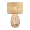 Diane champagne glass table lamp lit with a woven rattan drum shade and faceted base