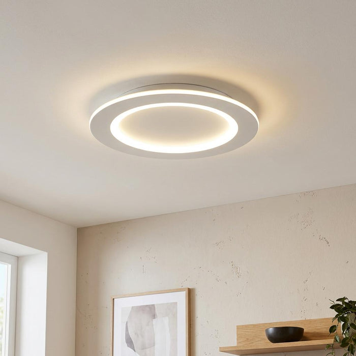 Round white LED ceiling flush light with an illuminated inner ring in a modern living room.