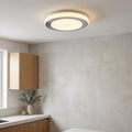 Round chrome flush ceiling light with double illuminated circles mounted on a white ceiling in a modern room.