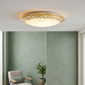 Round LED flush ceiling light with a gold leaf style rim illuminating a modern room with green walls.