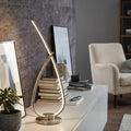Nickel Eglo Palozza curved LED table lamp with a glowing loop design on a white sideboard.