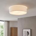 Eglo Pasteri white fabric drum ceiling light illuminated in a modern room with a grey wall and wooden furniture.