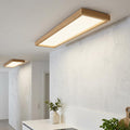 Rectangular oak-framed LED panel flush light illuminating a modern white-walled interior.
