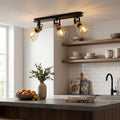 Industrial 3-light ceiling spotlight with brass wire shades and Edison bulbs in a modern kitchen setting.