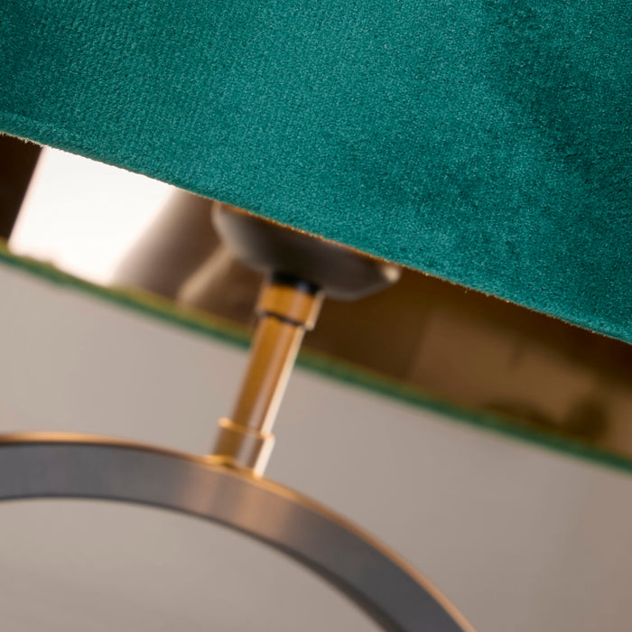 Detail of the Elegant lamp's brass fitting and black ring below a green velvet shade