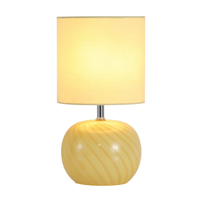 Fete yellow glass table lamp lit with a swirled glass base and cream cylinder shade