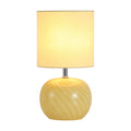 Fete yellow glass table lamp lit with a swirled glass base and cream cylinder shade