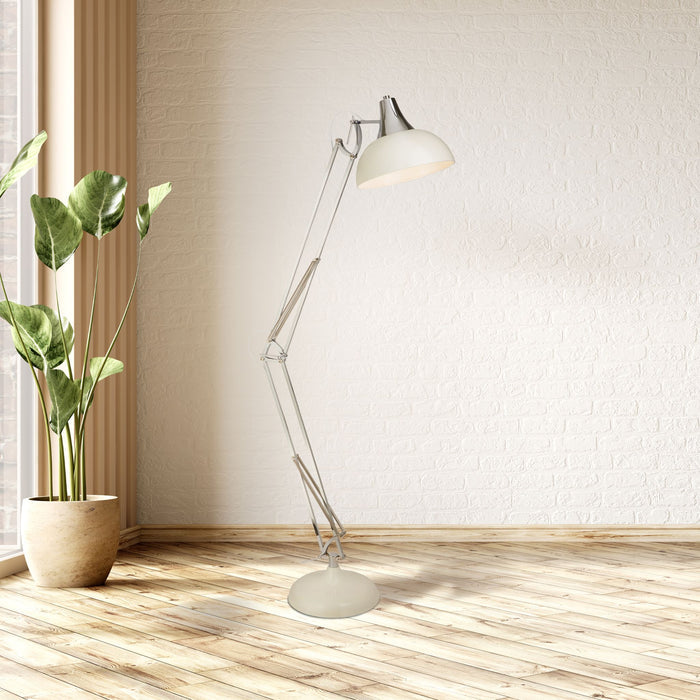 Goliath cream task floor lamp in a white brick room with a potted plant on pale wooden flooring