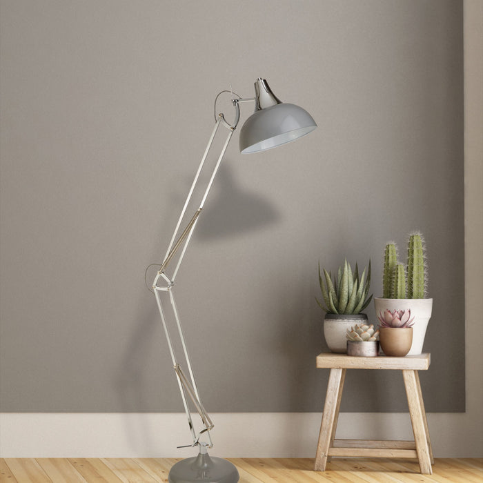 Goliath grey task floor lamp against a taupe wall beside a wooden stool with cacti in pots