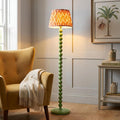 Higgledy green bobble floor lamp with an apricot zigzag shade beside a yellow armchair in a neutral living room.