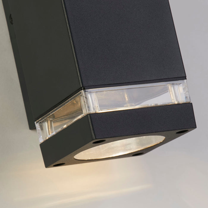 Close-up of the Houston light's grey square casing clear glass band and warm glow