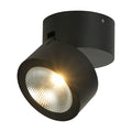 Manhattan matt black LED wall light lit as an adjustable round surface spotlight