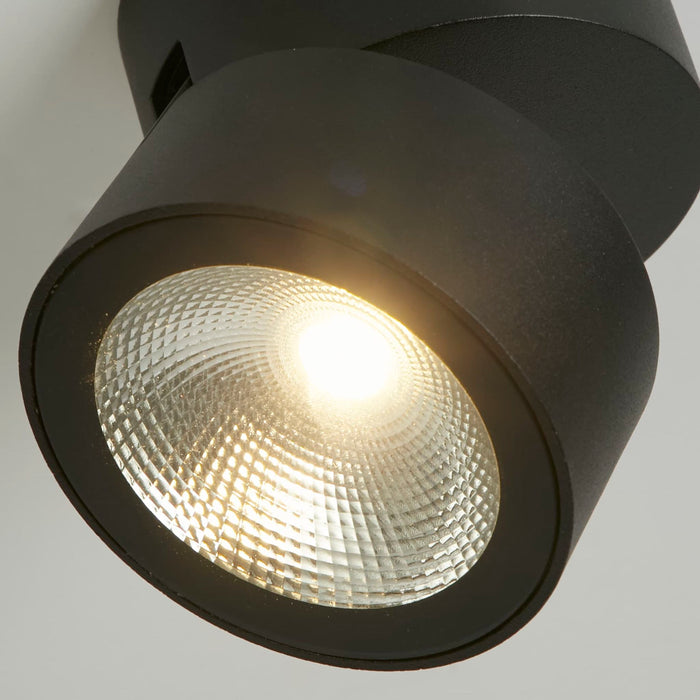 Close-up of the Manhattan spotlight's black housing and faceted warm LED reflector