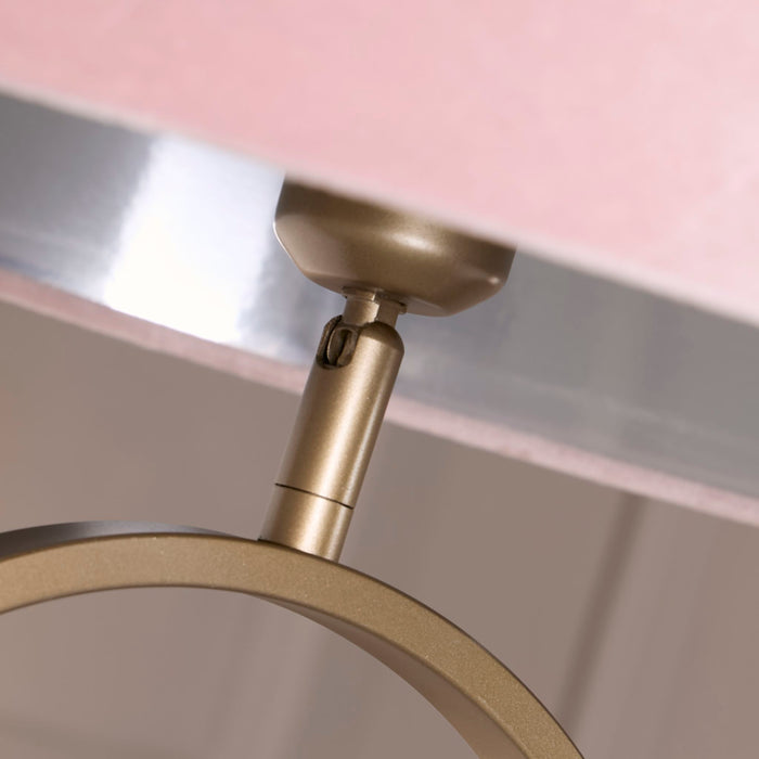 Close-up of the Modish bronze lamp fitting where the oval frame meets the pink velvet shade