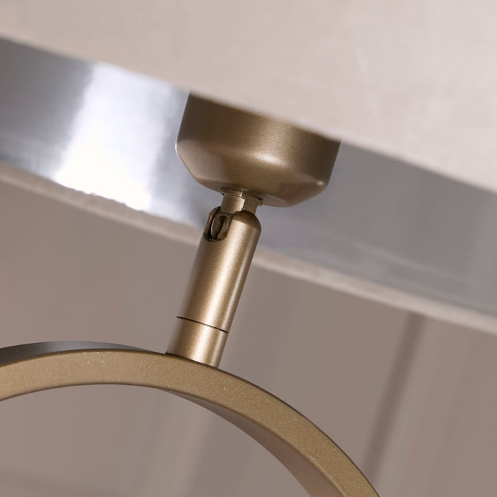 Close-up of the brushed bronze lamp holder meeting the taupe velvet shade on the oval frame