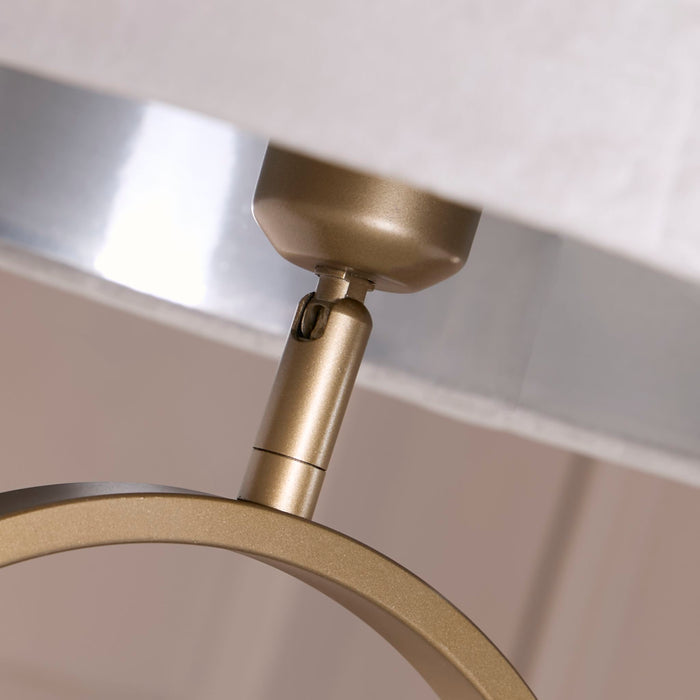 Close-up of the bronze lamp holder and oval frame beneath the grey velvet shade
