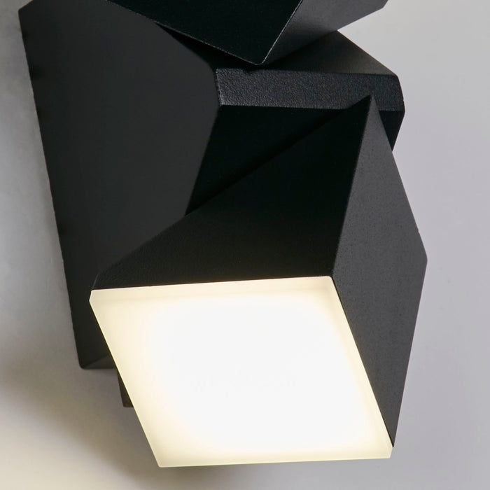 Close-up of the Montana wall light's angular black casing and square glowing diffuser