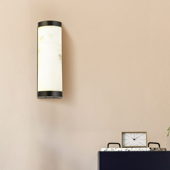 Blush-pink hallway wall with the Nile black wall light above a navy sideboard and clock