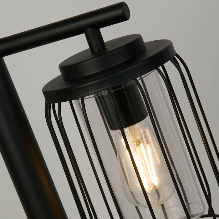 Close-up of the Reed lantern's black wire cage and clear glass cylinder with filament bulb