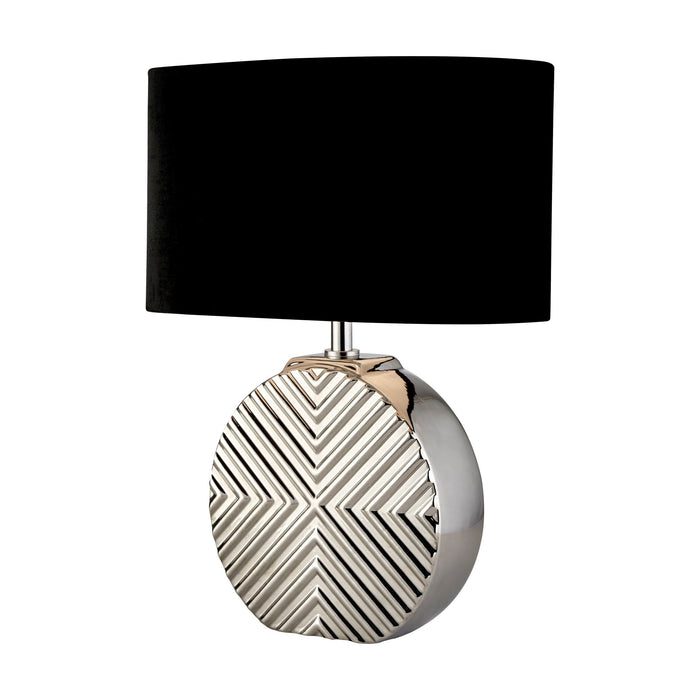 Regent chrome table lamp lit with a black shade above a geometric chevron mirrored base