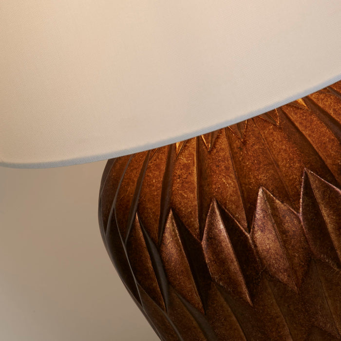 Detail of the Rosetta base's bronze petal facets meeting the cream fabric shade rim