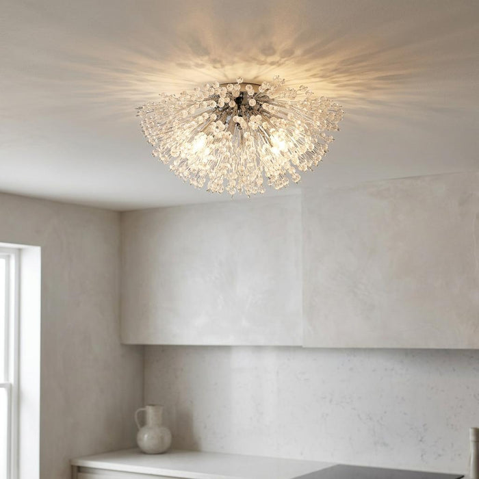 Chrome and glass bead sunburst ceiling light casting a decorative pattern on a white ceiling in a modern kitchen.