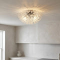 Chrome and glass bead sunburst ceiling light casting a decorative pattern on a white ceiling in a modern kitchen.