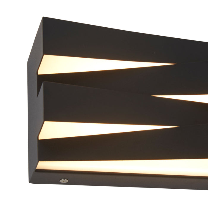Close-up of Section wall light's angled black fins and glowing wedge-shaped apertures