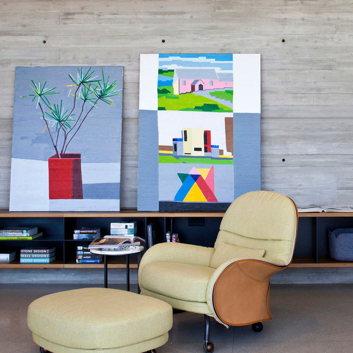 Concrete-walled living space with a lemon armchair and artwork suited to the Squary LED ceiling light