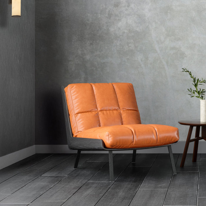 Wales black wall light on a grey concrete wall above a tan leather chair and side table with foliage