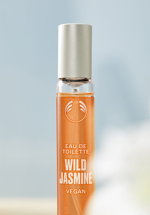 Roll-on bottle of Wild Jasmine eau de toilette with a silver cap on a light gradient background.